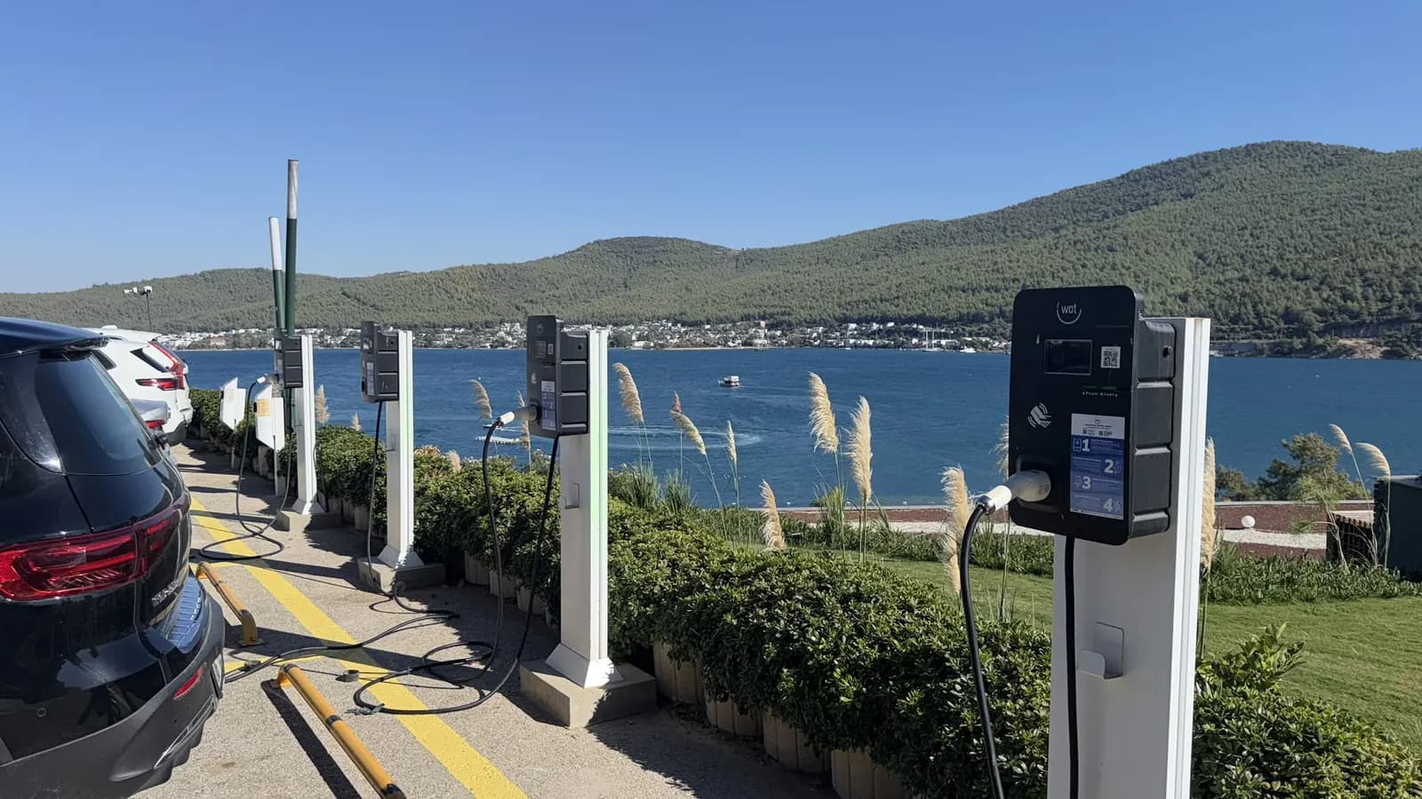 Deniz manzaralı otel otoparkında sıralı AC araç şarj istasyonları