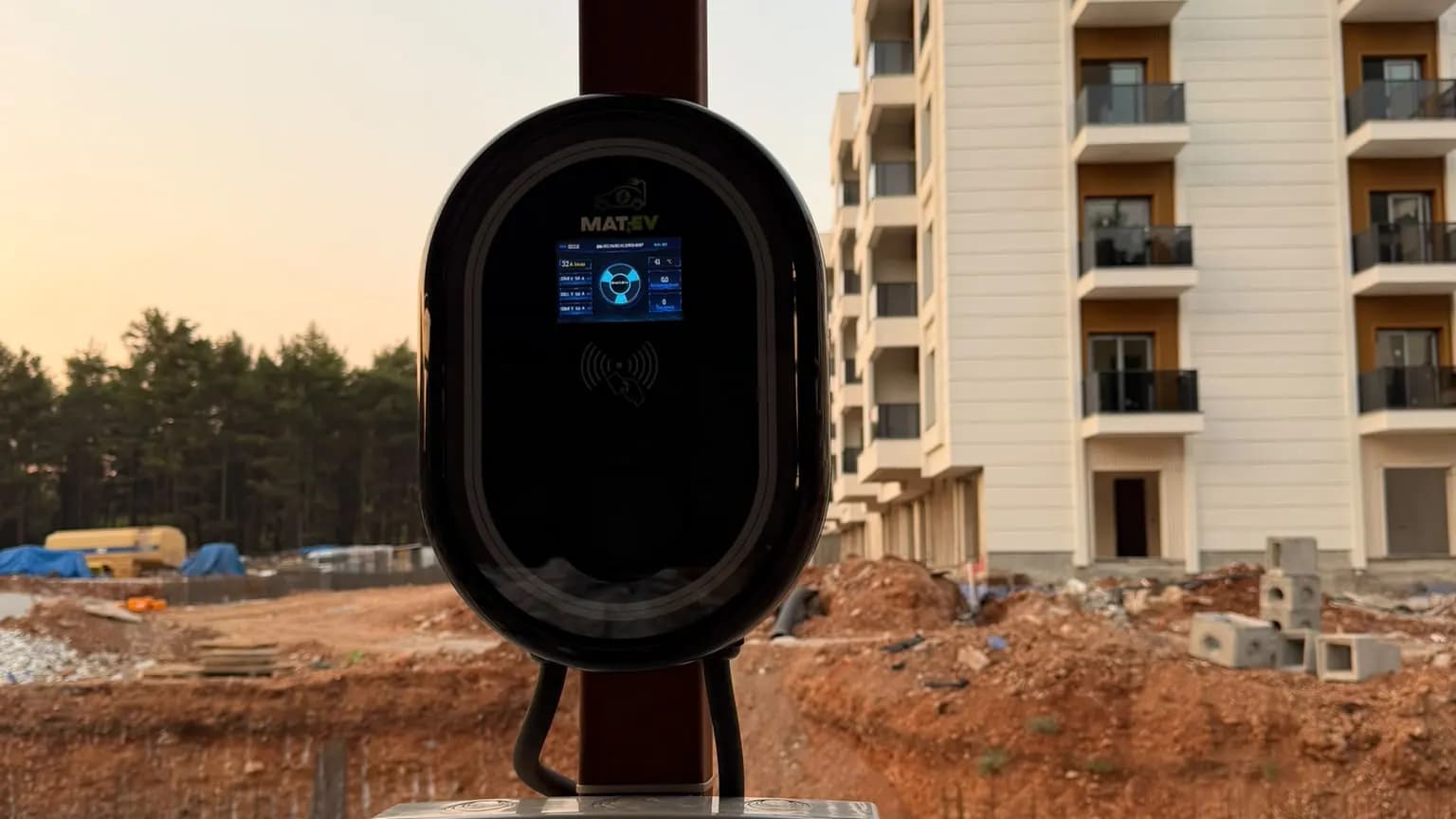 Yeni konut sitesi inşaatında direğe monte edilmiş akıllı wallbox araç şarj ünitesi